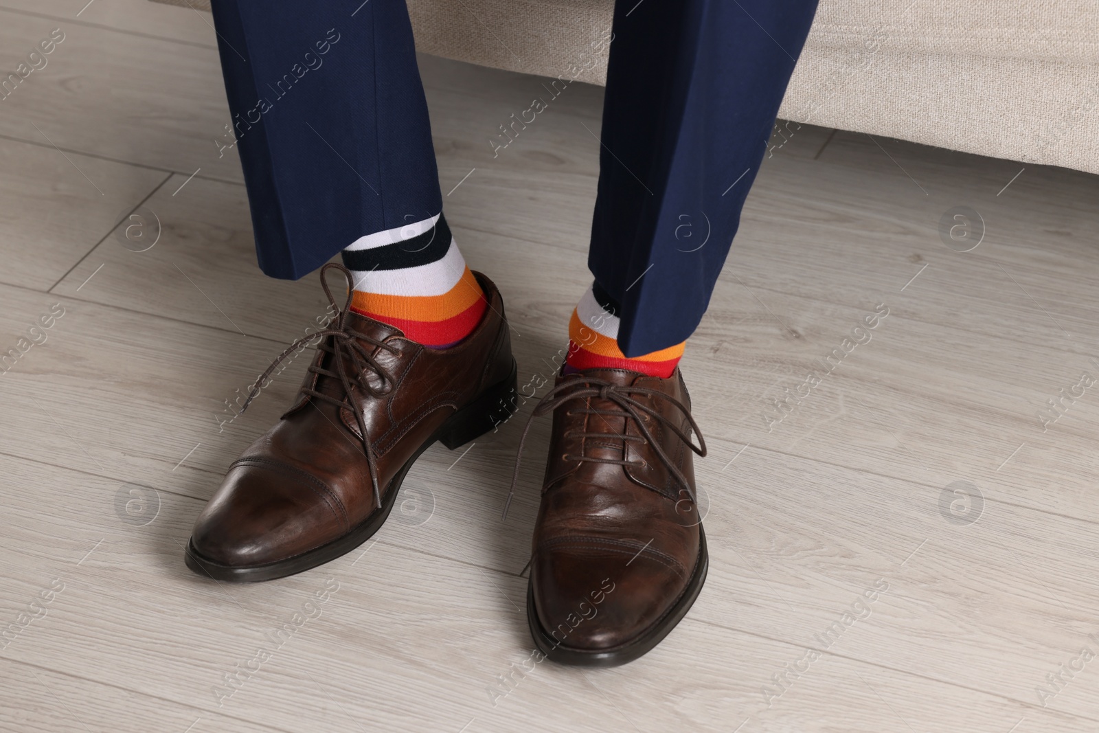 Photo of Man wearing stylish shoes and colorful socks indoors, closeup