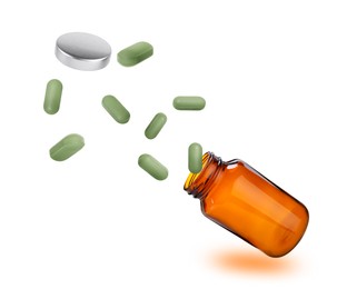 Image of Vitamin pills flying out from bottle on white background