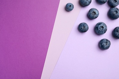 Photo of Flat lay composition with tasty blueberry and space for text on color background