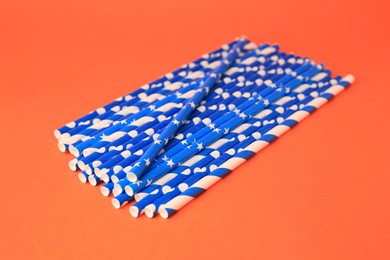 Many paper drinking straws on orange background