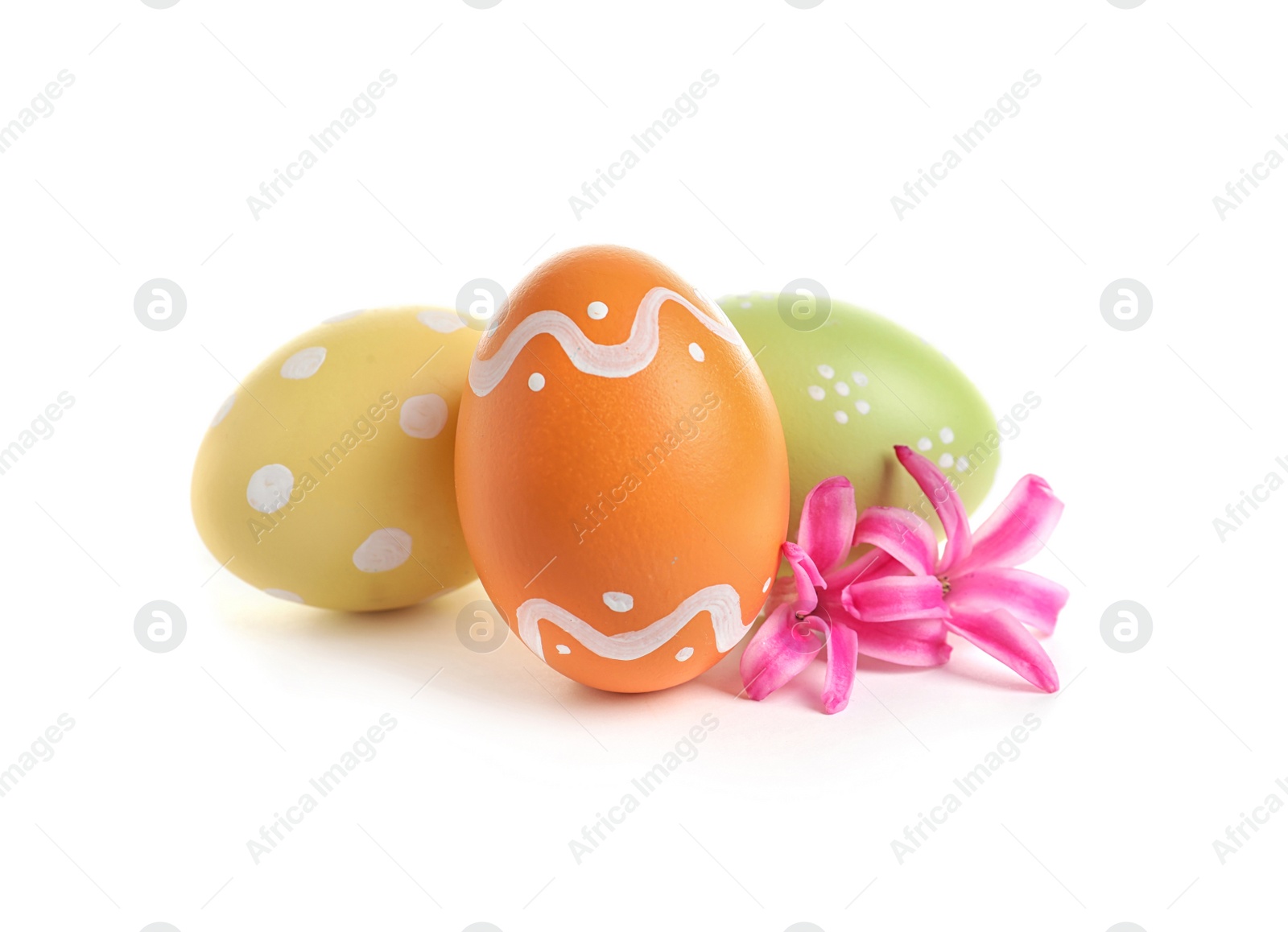 Photo of Colorful painted Easter eggs and flowers on white background
