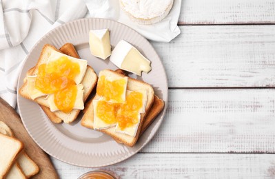 Photo of Tasty sandwiches with brie cheese and apricot jam on white wooden table, flat lay. Space for text