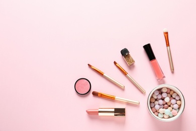 Photo of Flat lay composition with products for decorative makeup on pastel pink background