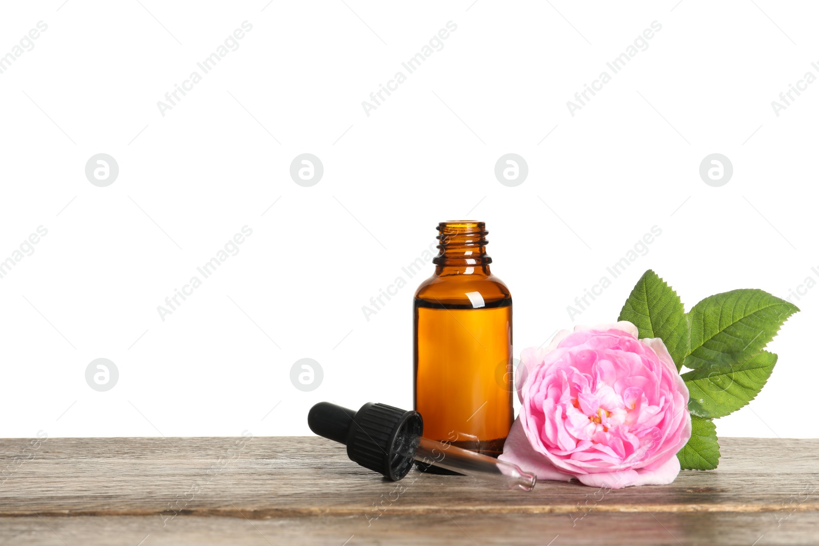 Photo of Bottle of rose essential oil, pipette and flower on table, white background