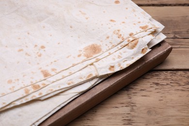 Photo of Delicious Armenian lavash on wooden table, closeup