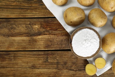 Photo of Starch and fresh raw potatoes on wooden table, flat lay. Space for text