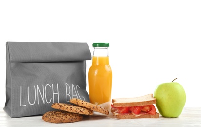 Photo of Lunch bag and appetizing food on table against white background