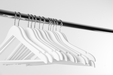 Photo of Metal rack with clothes hangers on white background