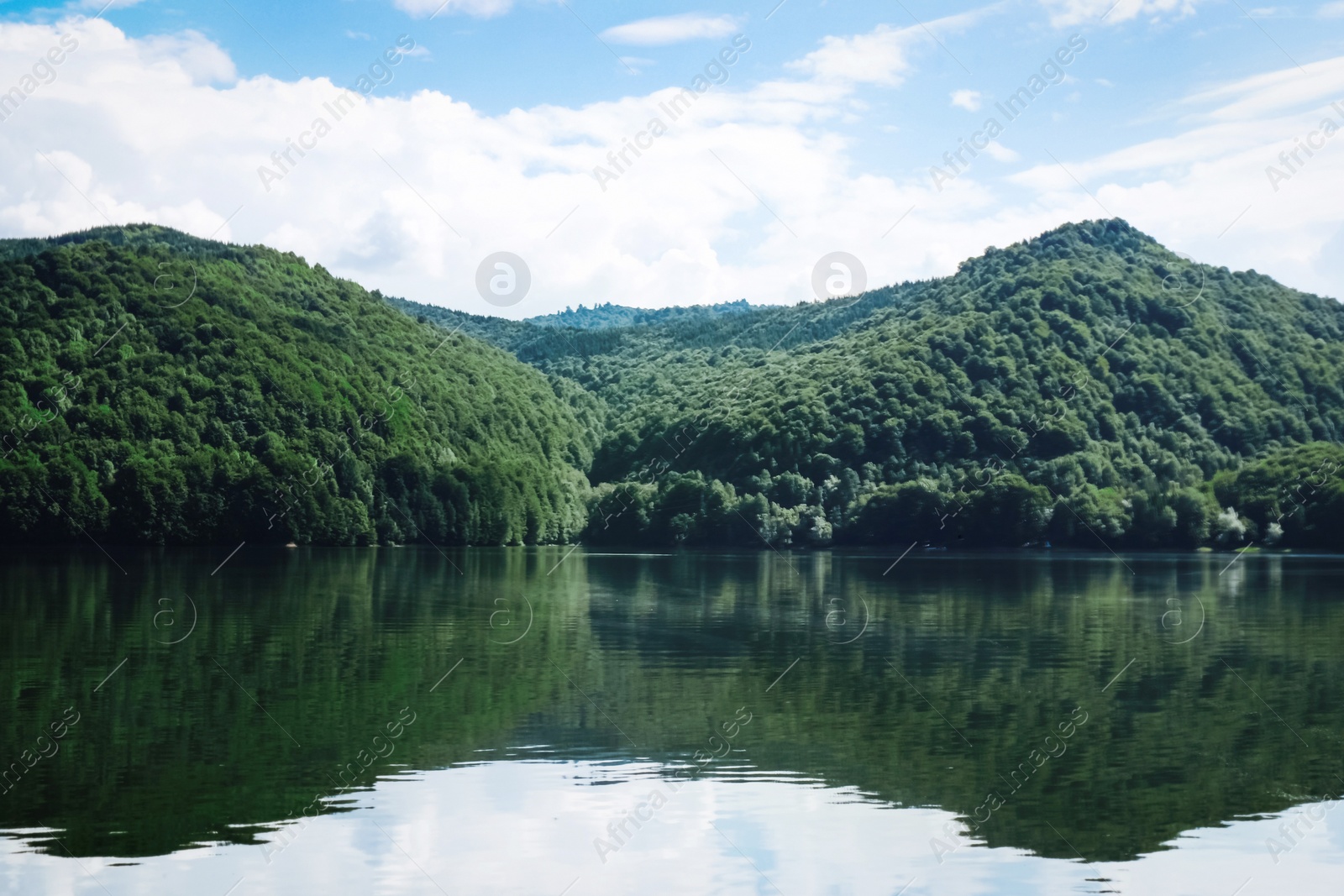 Photo of Picturesque view of beautiful lake surrounded by mountains on sunny day