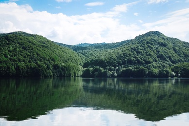 Photo of Picturesque view of beautiful lake surrounded by mountains on sunny day