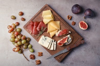 Photo of Sandwiches with ripe figs and delicious products on grey table, top view