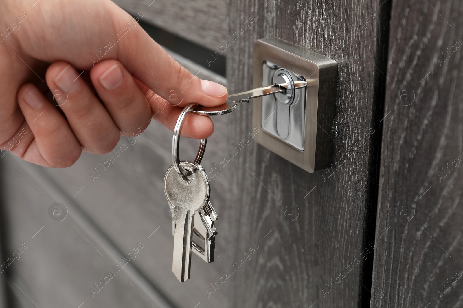 Photo of Woman unlocking door with key, closeup view