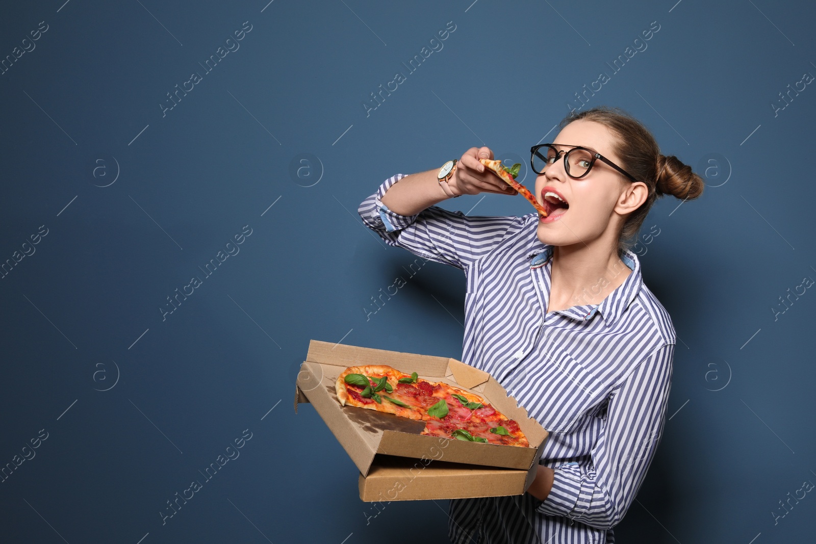 Photo of Attractive young woman with delicious pizza on color background