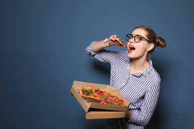 Photo of Attractive young woman with delicious pizza on color background