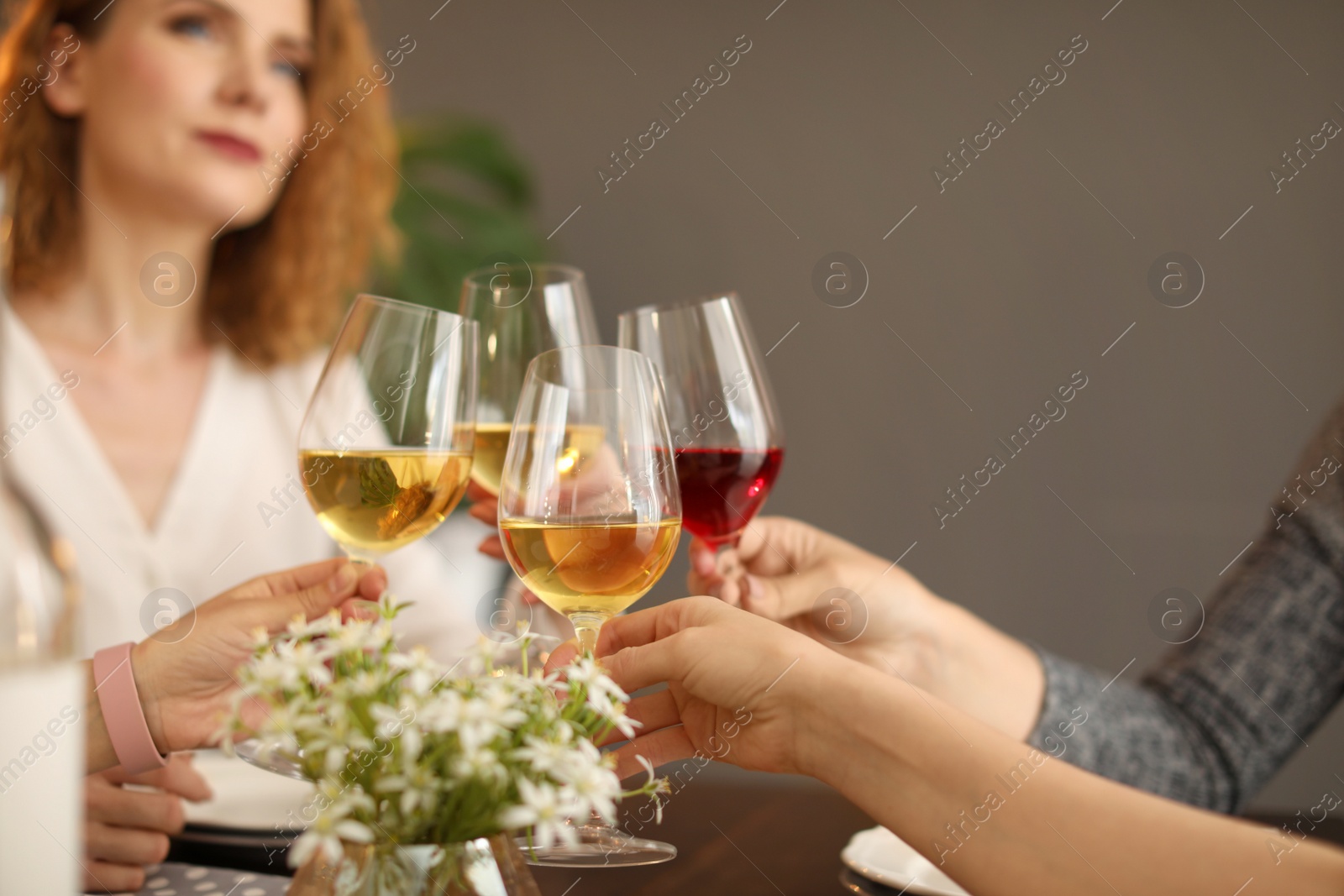 Photo of Young people with glasses of delicious wine at table