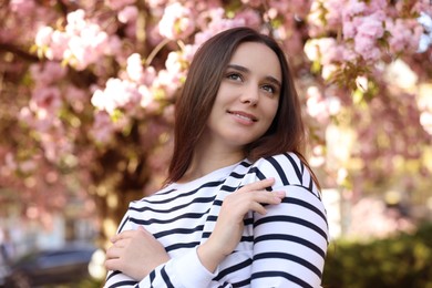 Beautiful woman near blossoming tree on spring day