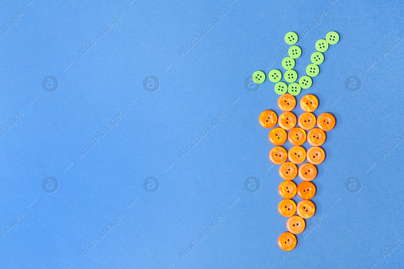 Photo of Carrot shape made with color buttons on blue background, flat lay. Space for text