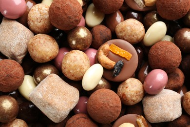 Photo of Different delicious chocolate candies as background, closeup