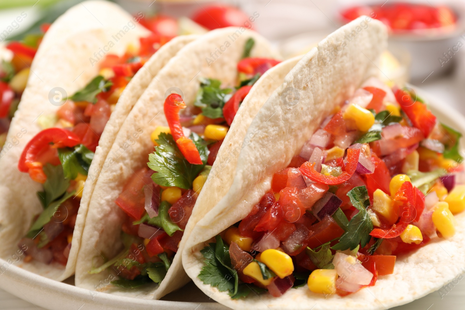 Photo of Tasty tacos with vegetables on table, closeup