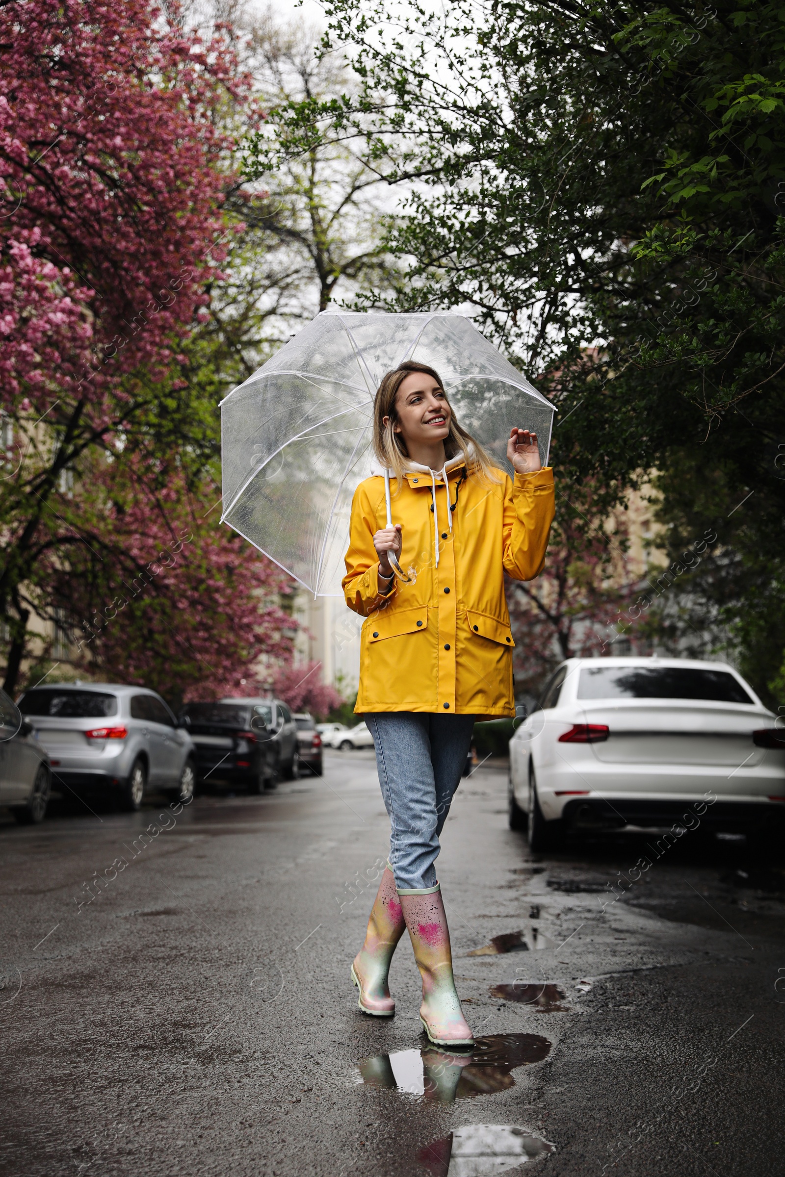 Photo of Young woman with umbrella walking on spring day