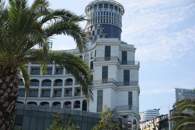 BATUMI, GEORGIA - JUNE 10, 2022: Beautiful view of Sea Towers Suit hotel and palm trees outdoors