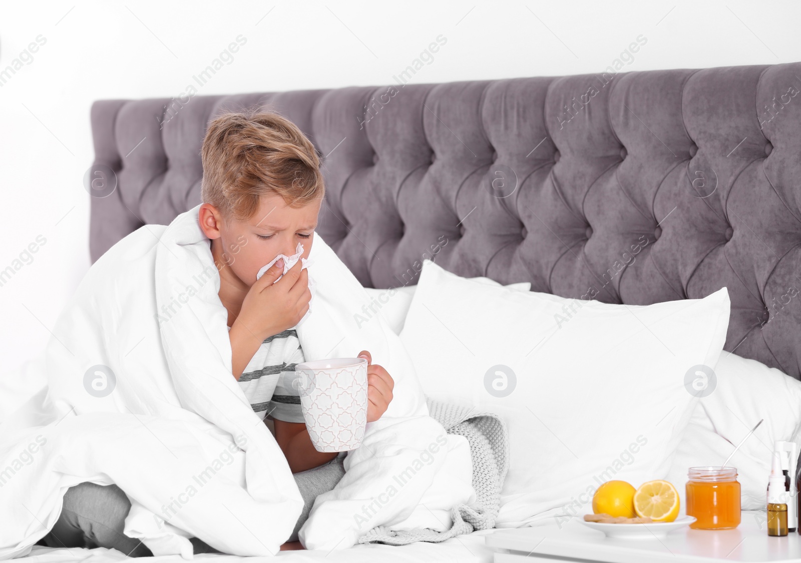 Photo of Ill little boy with cup of hot tea for cough at home. Space for text