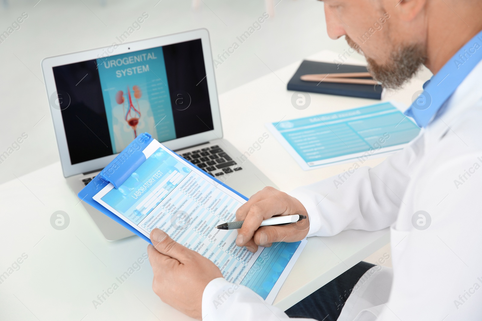 Photo of Mature urologist working at table in hospital