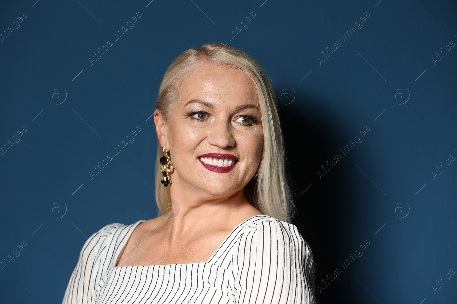 Photo of Portrait of beautiful mature woman on blue background