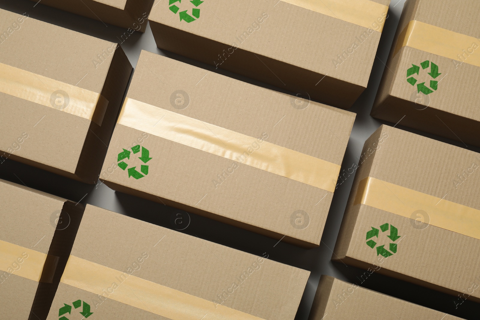 Image of Cardboard boxes with recycle sign stamps on grey background, flat lay