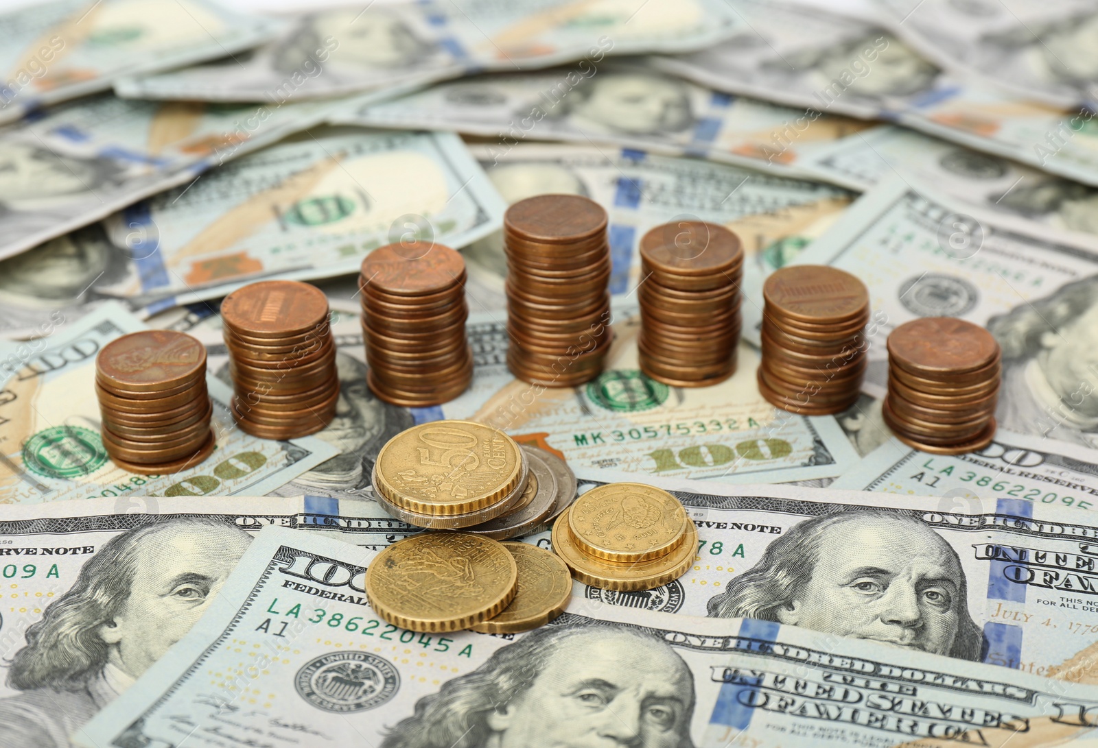 Photo of Stacks of metal coins on dollar banknotes