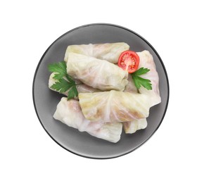 Photo of Plate with uncooked stuffed cabbage rolls, tomato and parsley isolated on white, top view