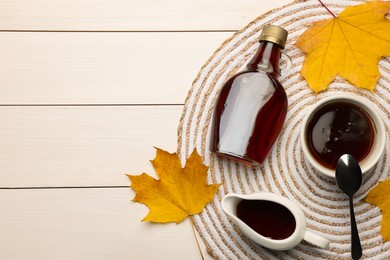 Photo of Flat lay composition with tasty maple syrup and dry leaves on white wooden table, space for text