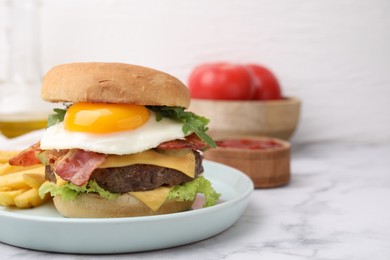 Delicious burger with fried egg and french fries served on white marble table, closeup. Space for text