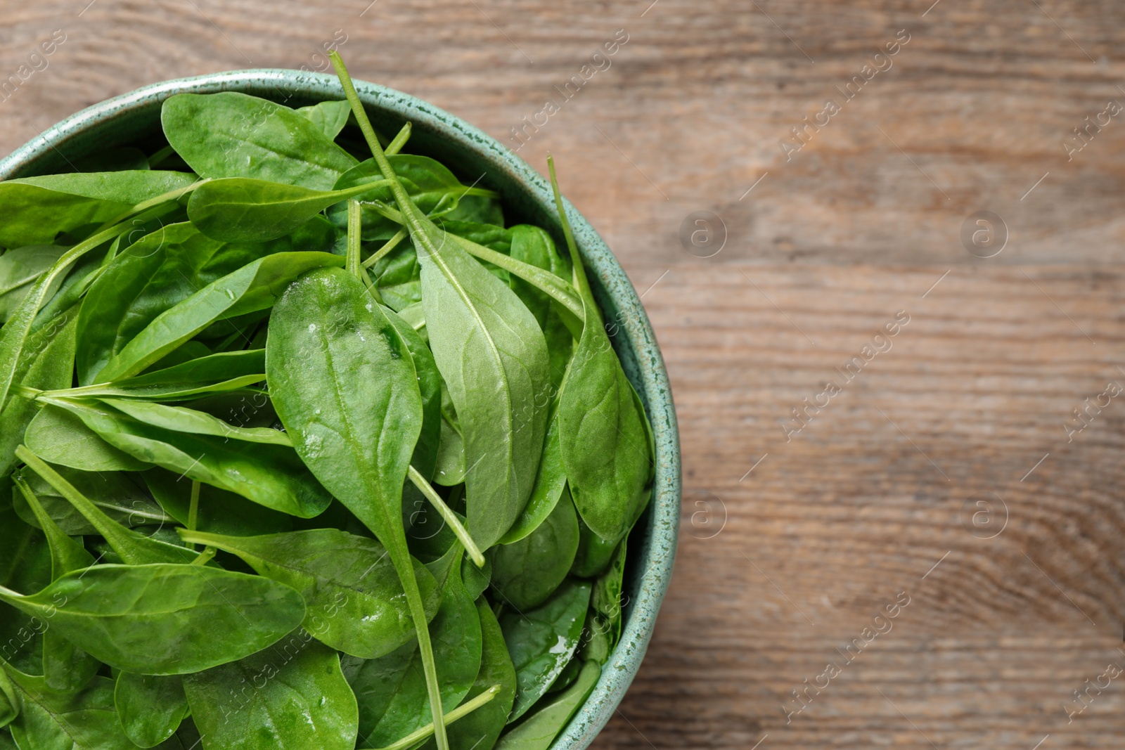 Photo of Fresh green healthy spinach on wooden table, top view. Space for text