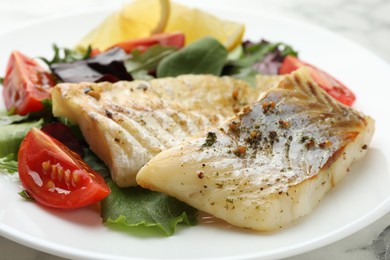 Photo of Tasty cod cooked with salad on table, closeup