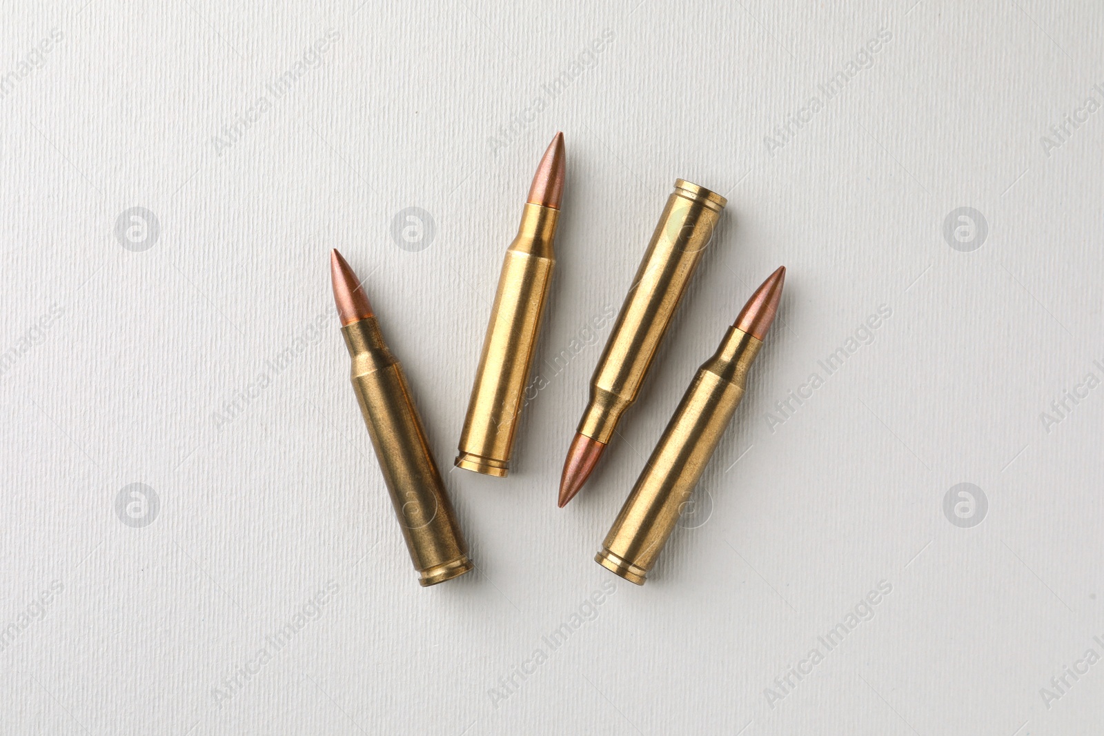 Photo of Brass bullets on white background, flat lay