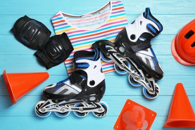 Flat lay composition with inline roller skates on wooden background