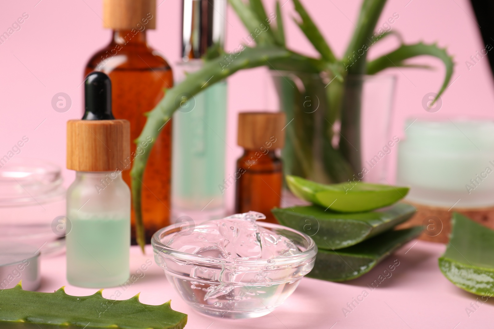 Photo of Bowl with natural gel and fresh aloe on pink background, closeup