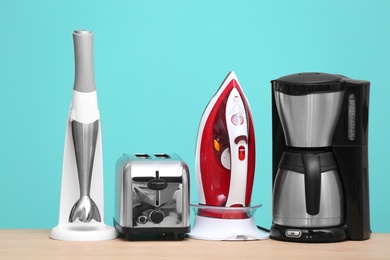 Photo of Household and kitchen appliances on table against color background. Interior element