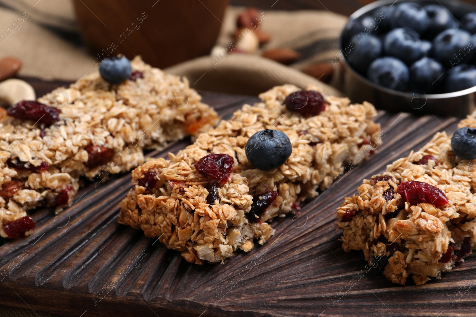 Photo of Tasty granola bars with berries on table, closeup
