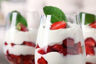 Photo of Delicious strawberries with whipped cream in glass, closeup. Space for text