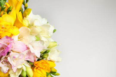 Photo of Beautiful colorful freesia bouquet on grey background, closeup. Space for text