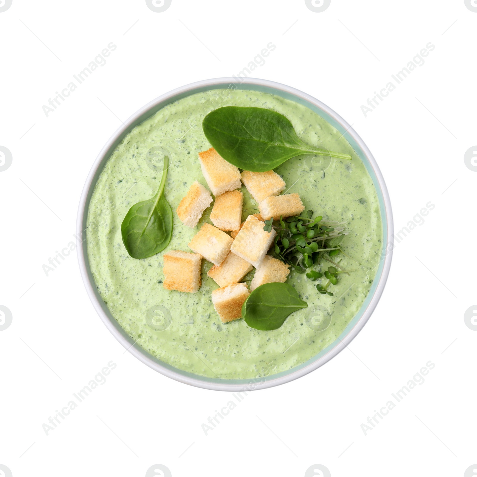 Photo of Delicious spinach cream soup with croutons in bowl isolated on white, top view