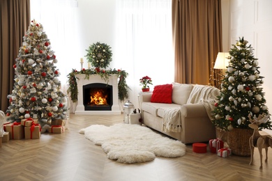 Photo of Festive living room interior with Christmas trees and fireplace