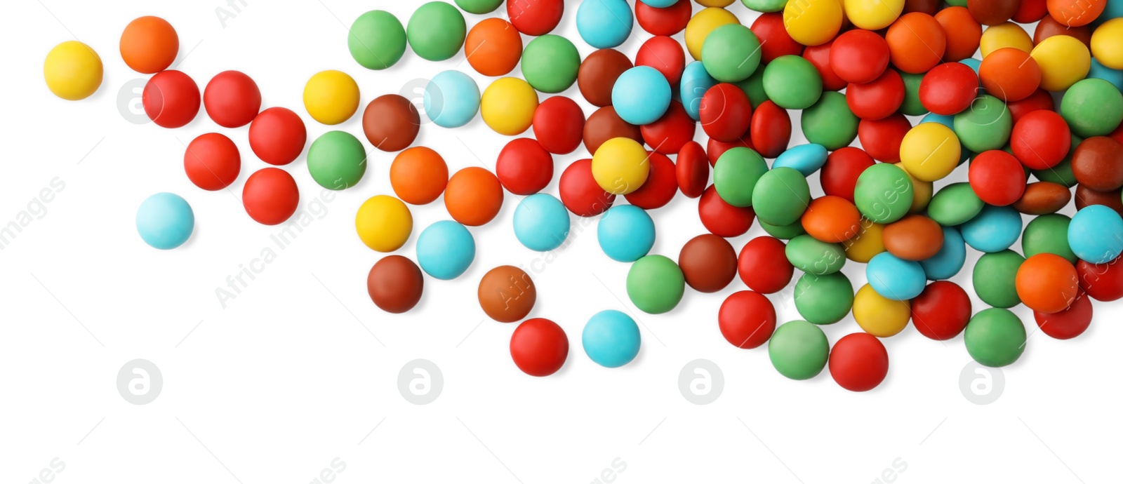 Photo of Many small colorful candies on white background, top view