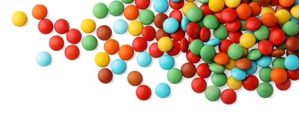 Many small colorful candies on white background, top view