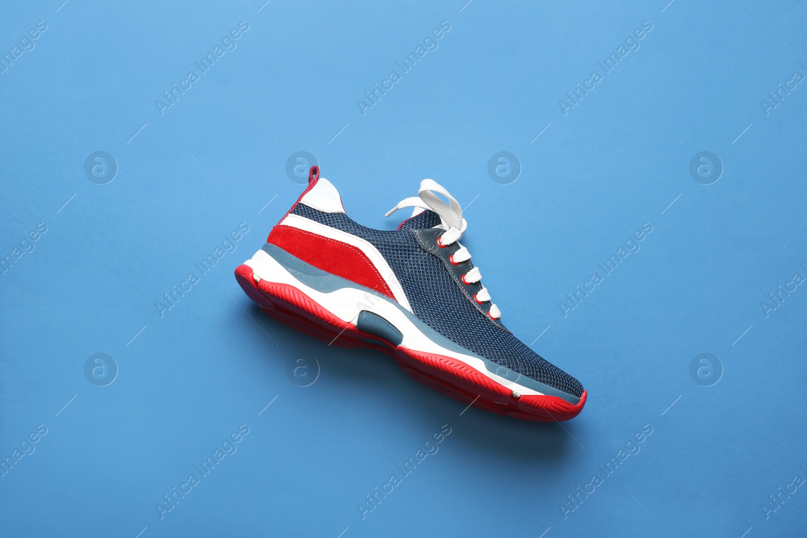 Photo of Stylish modern training shoe on color background, top view
