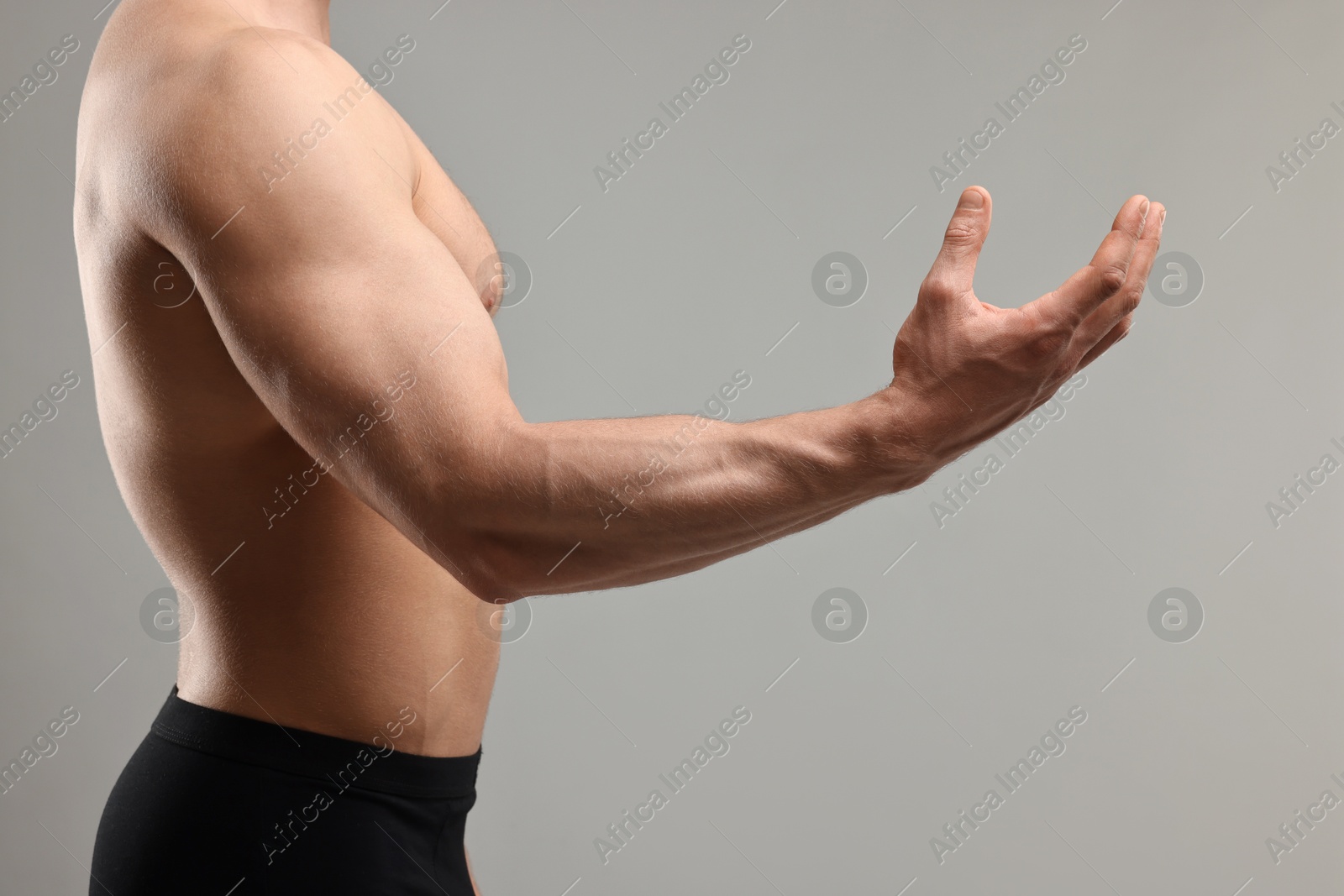 Photo of Man with muscular body on light grey background, closeup