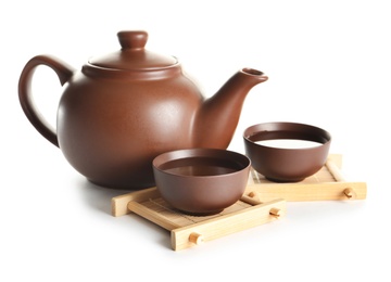 Photo of Cups and teapot of freshly brewed oolong on white background