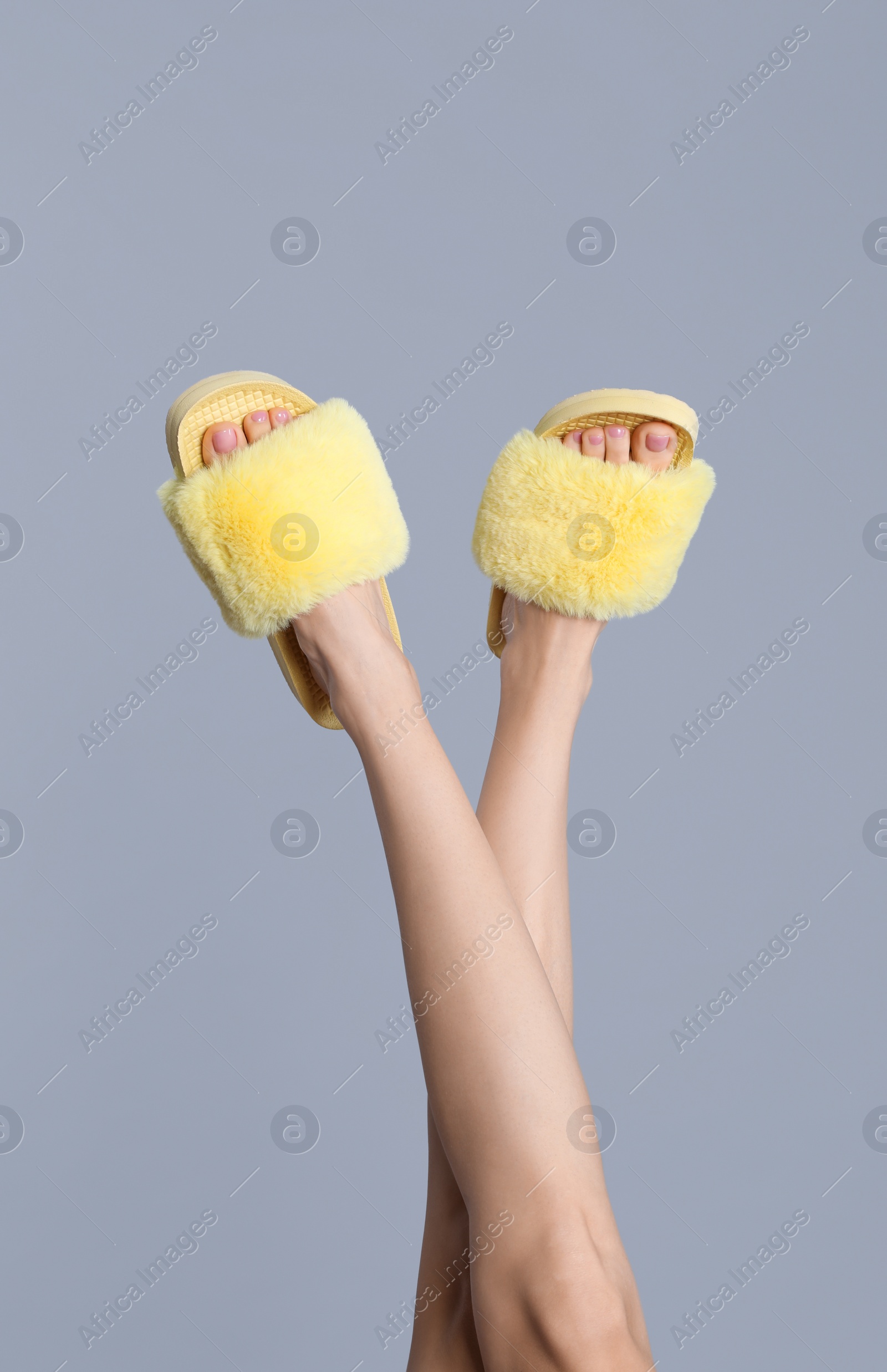 Photo of Woman wearing stylish slippers on grey background, closeup